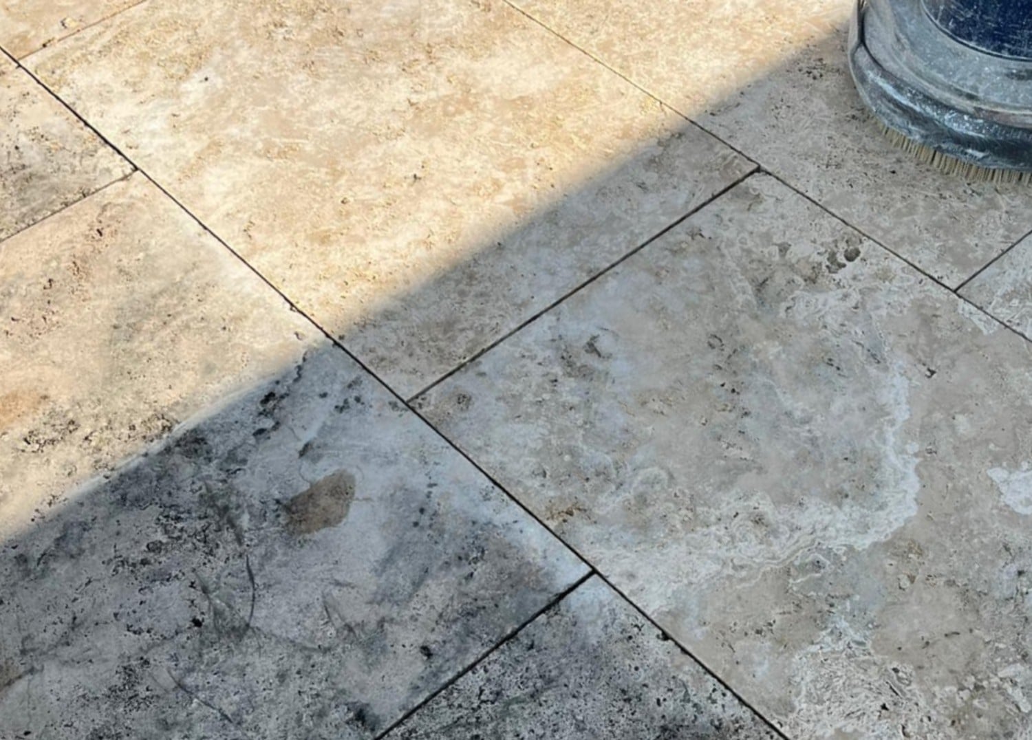 Travertinplatten im Außenbereich Travertinplatten im Außenbereich mit Schmutz und Flecken, die durch falsche Pflege oder ungeeignete Reinigungsmethoden entstanden sind.